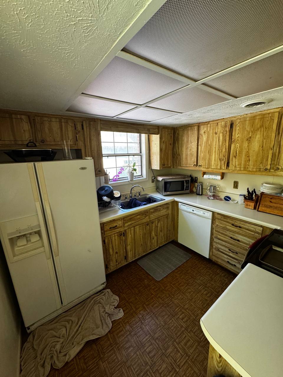 Original kitchen with dated wood cabinets in the Hendersonville house