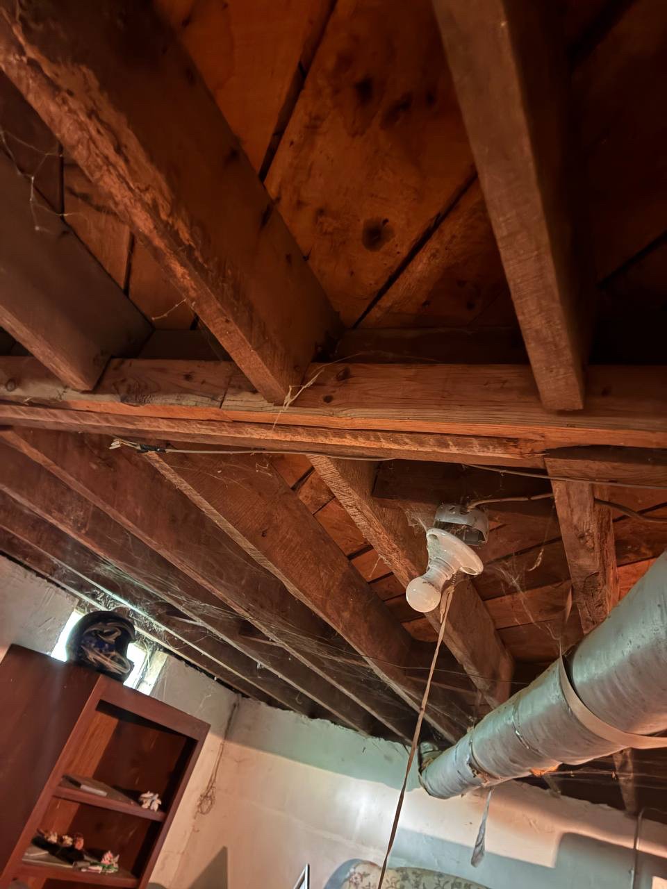 Old floor joists and exposed wiring in the basement