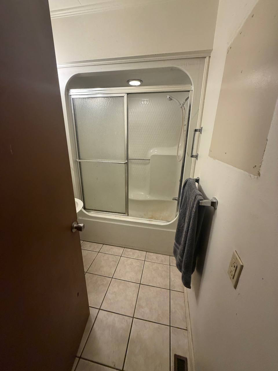 Dated bathroom with tub and shower in the Morganton house