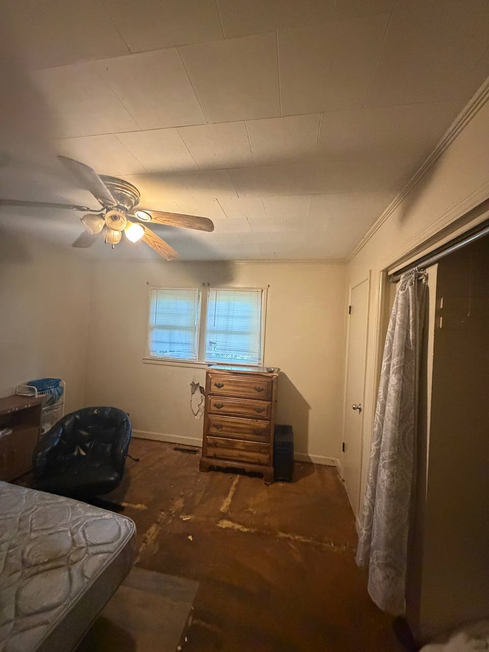 Bedroom with flooring removed and damaged wall